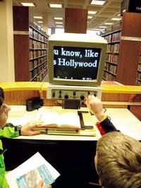 Mindstorms Mayhem team members Nathan Streeter, left, and David Schunemann use a book magnifier at the Nashua Public Library.
